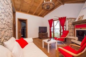 sala de estar con sofá blanco y sillas rojas en Villa Milena, en Brseč