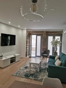 uma sala de estar com um sofá azul e uma televisão em Apartamento Alto da Valeta em Arcos de Valdevez