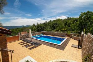 a swimming pool on a patio next to a house at Villa Milena in Brseč