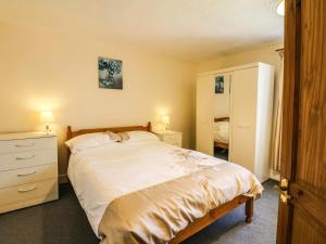 a bedroom with a large white bed and a dresser at The Barton in Bideford