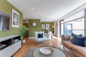 a living room with green walls and a couch at SECC Hydro Executive 7 Apartment in Glasgow