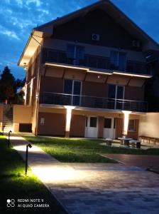 a building with lights on the side of it at Karos Bianco Apartmanház in Zalakaros