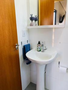 uma casa de banho com um lavatório branco e um espelho. em Maritimus Suites 06 em Barretos