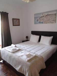 een slaapkamer met een groot bed en 2 handdoeken bij FAMILY APARTMENT LISBON-ESTORIL in Estoril