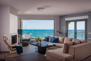 a living room with a couch and a view of the ocean at Coast Suite-Luxury Central Beach House in Hersonissos