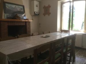 a room with a table with chairs and a fireplace at La montagna incantata in Isola del Gran Sasso dʼItalia