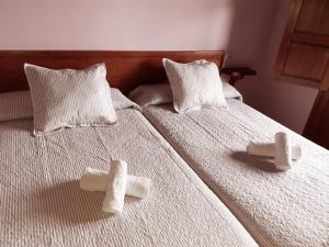 dos almohadas en una cama con cruces en ella en La casina de Berdayes, en Labra