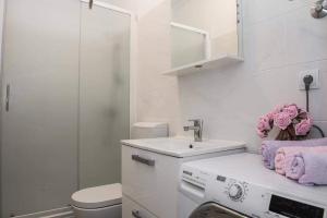 a white bathroom with a sink and a washing machine at Apartman Cezar2 in Rogoznica +37 photos