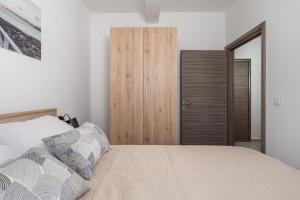 - une chambre avec un lit et un placard en bois dans l'établissement Apartments Vila Belvedere, à Rijeka