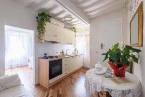 Appartamento incantevole nel centro di Arezzo في أريتسو: مطبخ مع طاولة وموقد فرن علوي