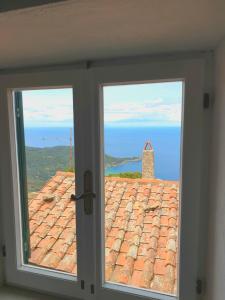 a window with a view of a tile roof at alcastello - Casamatta via Dante Alighieri,36 in Isola del Giglio
