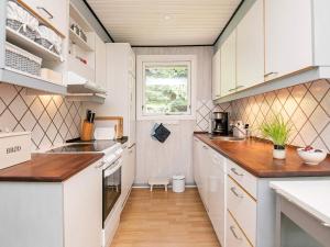 een kleine keuken met witte kasten en een raam bij 5 person holiday home in Tranek r in Tranekær