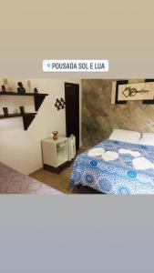 a bedroom with a bed with a blue comforter at Pousada e Restaurante Sol e Lua in Mucuri