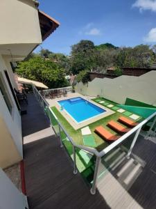 an outdoor deck with a swimming pool and chairs at Chalés Paraiso de Pipa in Pipa