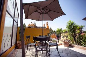a table and chairs with an umbrella on a balcony at Majikal B&B - Mirador in Puebla +4 photos
