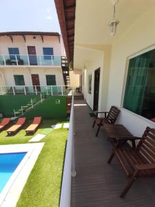 a balcony of a building with benches and a swimming pool at Chalés Paraiso de Pipa in Pipa
