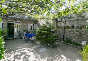 un patio con mesa y sillas bajo una pérgola en Apartment Ivo & Mare, en Dubrovnik