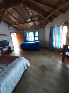 ein Schlafzimmer mit einem blauen Bett und einem Sofa in der Unterkunft Hotel Campestre Inaoska Ecospa in Nobsa