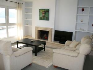 sala de estar con 2 sillas, mesa y TV en Belvilla by OYO Apartament Altea Mar, en Altea