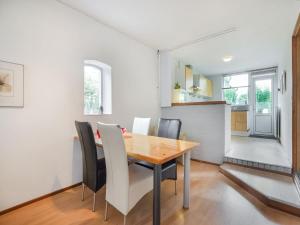 eine Küche und ein Esszimmer mit einem Holztisch und Stühlen in der Unterkunft Serene Bungalow in Landgraaf with Terrace and Nature Garden in Landgraaf