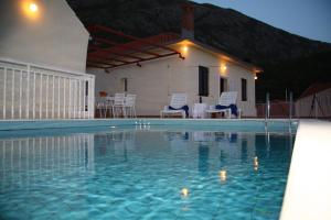 a swimming pool in front of a house at Holiday Home Urlović in Gruda