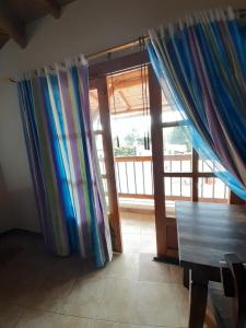 Zimmer mit einem Holztisch und einer Glasschiebetür in der Unterkunft Hotel Campestre Inaoska Ecospa in Nobsa