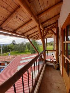 einen Balkon mit einem Holzdach und Aussicht in der Unterkunft Hotel Campestre Inaoska Ecospa in Nobsa