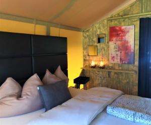 a bedroom with a large bed with a black headboard at GIFFORD Island Getaway - Just You and Nature in Mahone Bay