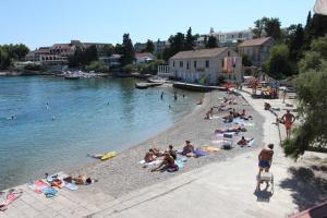 a group of people on a beach near the water at Apartments Mir - perfect location & cosy in Korčula