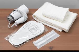 a hair dryer and towels on a wooden table at NAGAHORI HAIRU DOTONBORI CONDO in Osaka