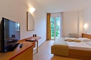 sypialnia z łóżkiem i telewizorem z płaskim ekranem w obiekcie Villa Lovorka - Hotel Resort Dražica w Krku