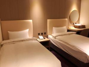 a hotel room with two beds and a mirror at Michi Hotel - Luodong in Luodong