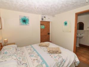 a bedroom with a bed with towels on it at The Bushel in Bideford