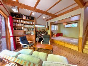 een woonkamer met een bed, een bank en stoelen bij Pop Inn Hakuba in Hakuba