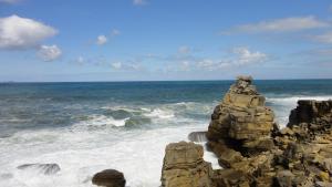 a stack of rocks on the shore of the ocean at Santa Maria do Mar Guest House in Peniche