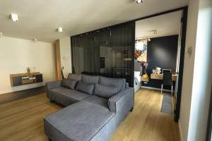 uma sala de estar com um sofá cinzento e uma mesa em Apartament EXCLUSIVE FYRTEL WILDA - NEW em Poznań