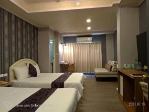 a hotel room with two beds and a television at Guan Lun Hotel in Hualien City