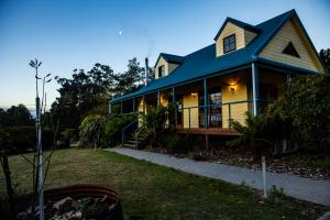 una casa con techo azul y patio en Little Norfolk Bay Events and Chalets en Taranna