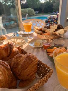 una mesa cubierta con pan y zumo de naranja y un coeficiente de eficiencia suficiente de zumo de naranja en Le Jardin de LaCoste, en Narbona