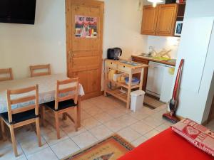 cocina con mesa, sillas y barra en Appartement Les Deux Alpes, 2 pièces, 4 personnes - FR-1-516-145 en Mont-de-Lans