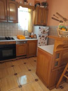 a kitchen with wooden cabinets and a refrigerator at Kuća - vikendica in Kotor