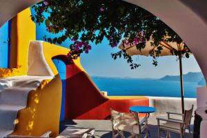 a room with a view of the ocean and a table and chairs at Chroma Suites in Oia