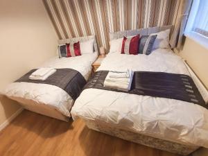two beds sitting next to each other in a bedroom at BRIGSTOCK HOLIDAYS HOUSE in Manchester