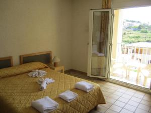 a hotel room with two beds and a balcony at Motel Saint Francois in Calvi