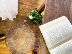 a book on a table next to a chair with a book at Archontika Karamarlis in Makrinitsa