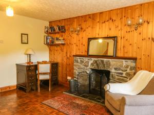 a living room with a stone fireplace and a mirror at Corranbuie in Tarbert