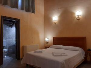 - une chambre avec un lit et une salle de bains avec des toilettes dans l'établissement Palazzo Marzano, à Briatico