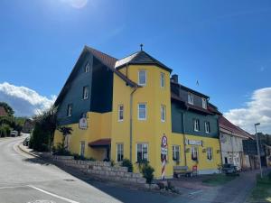 a yellow building on the side of a street at Landgasthaus Zander in Blankenburg