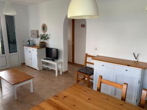 a living room with a table and a television at Ca la Marta apartamento con piscina y jardín a 150m de la playa in Arenal d'en Castell