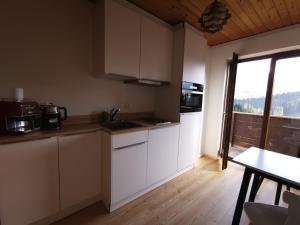 a kitchen with white cabinets and a table and a window at Panorama in Warth am Arlberg